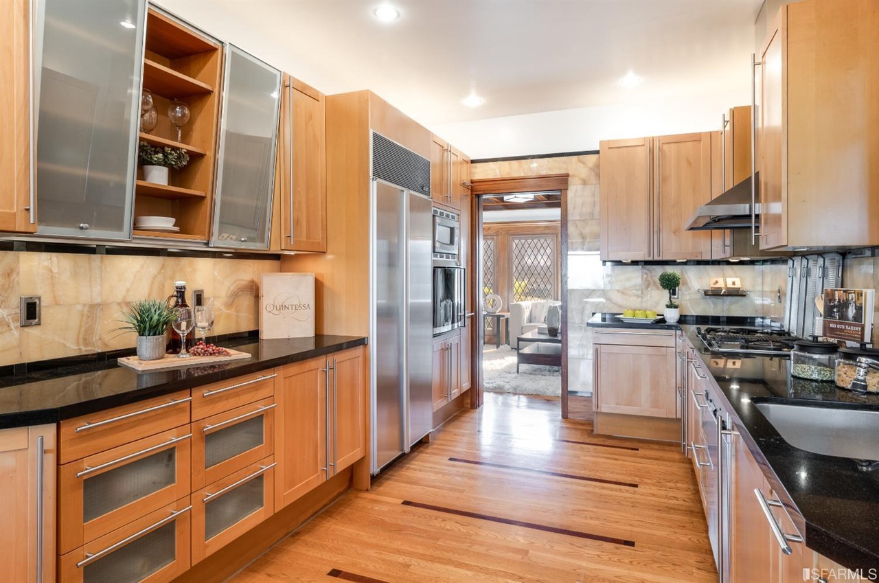 Property Photo: Kitchen, featuring high-end appliances and wood floors