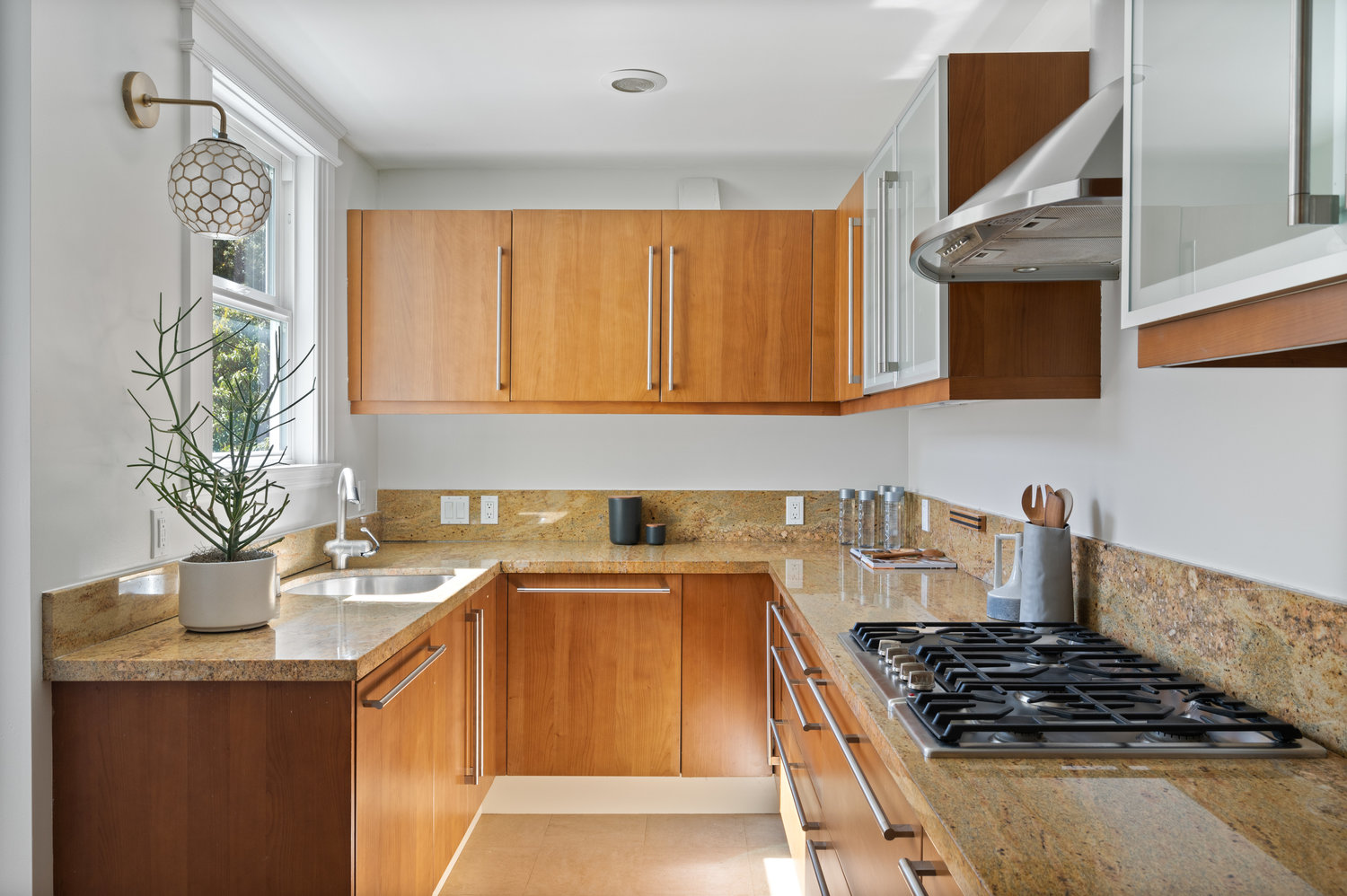 Property Photo: View of the U-shaped kitchen, featuring beautiful wood cabinets 