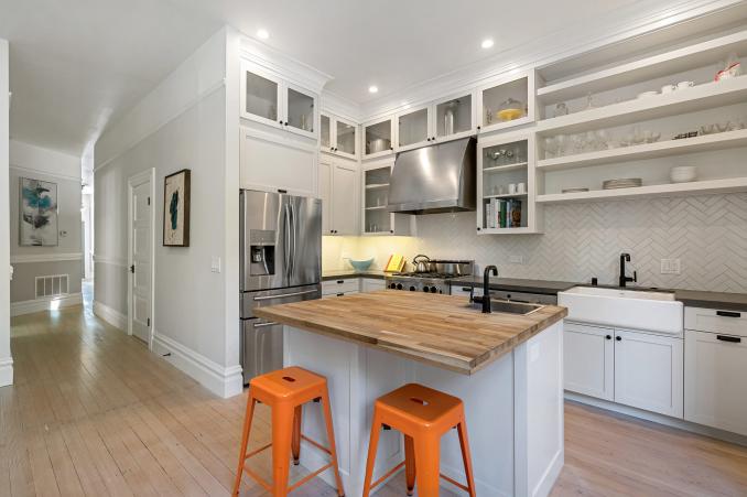 Property Thumbnail: View of the kitchen, featuring white cabinets and wood floors