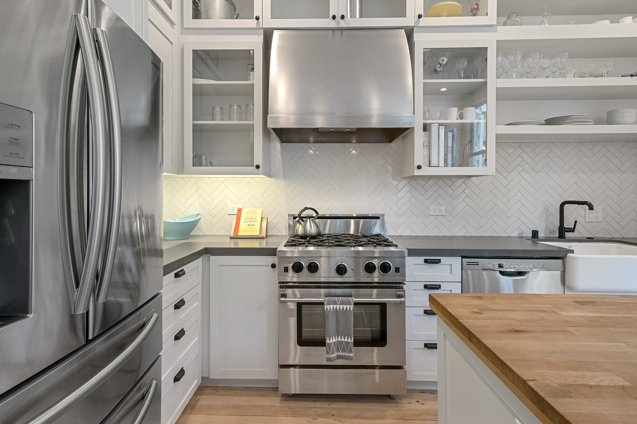 Property Photo: Kitchen with stainless steel appliances and glass front cabinets