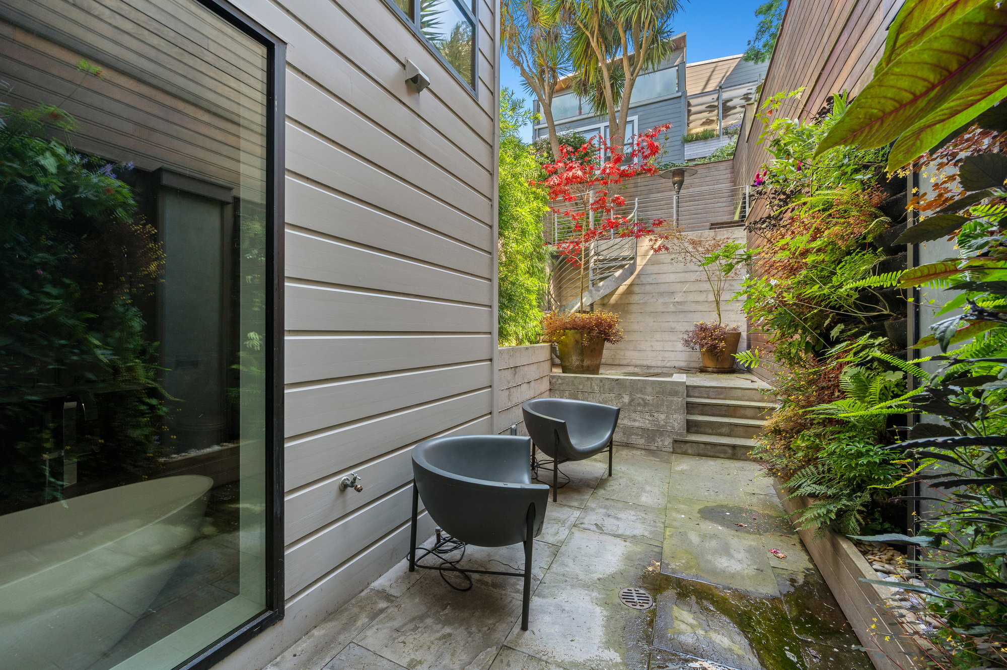Property Photo: Paito off of the primary suit. There is a sitting area and a living wall.