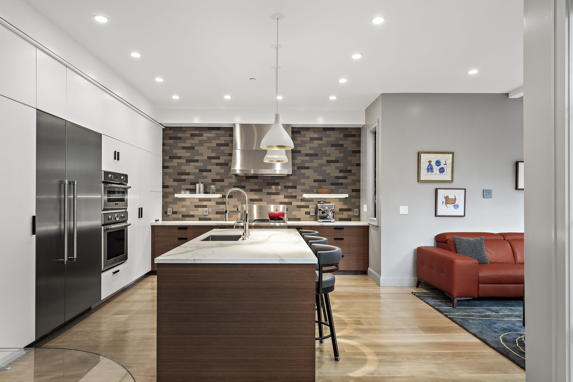 Property Photo: Looking into the kitchen of Unit 1. There is a large island with sink and stools. 