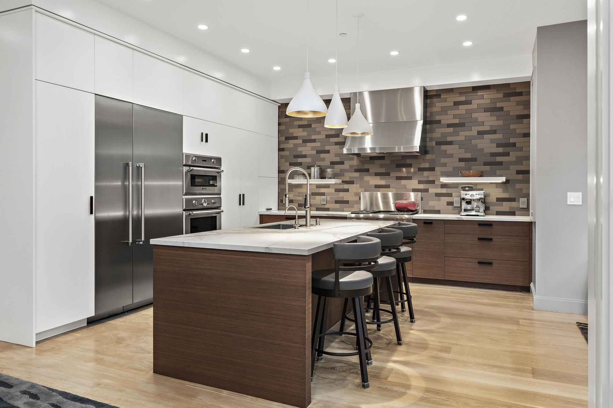 Property Photo: The left side wall in the kitchen in built in cabinets, stoves, and fridge. All stainless steel appliances. 