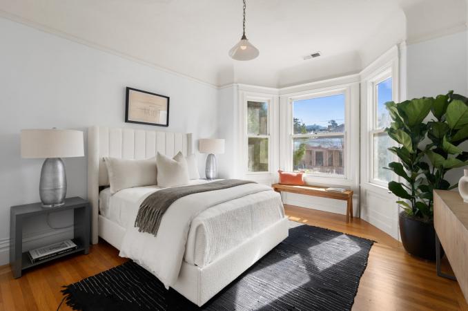 Property Thumbnail: Front guest room has queen bed with two bedside tables. There is a bench under bay windows and hardwood floors through out.