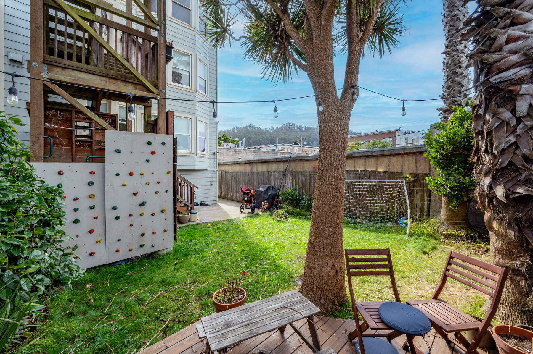 Property Photo: Photo of shared yard. There is grass and a sitting area on small deck.