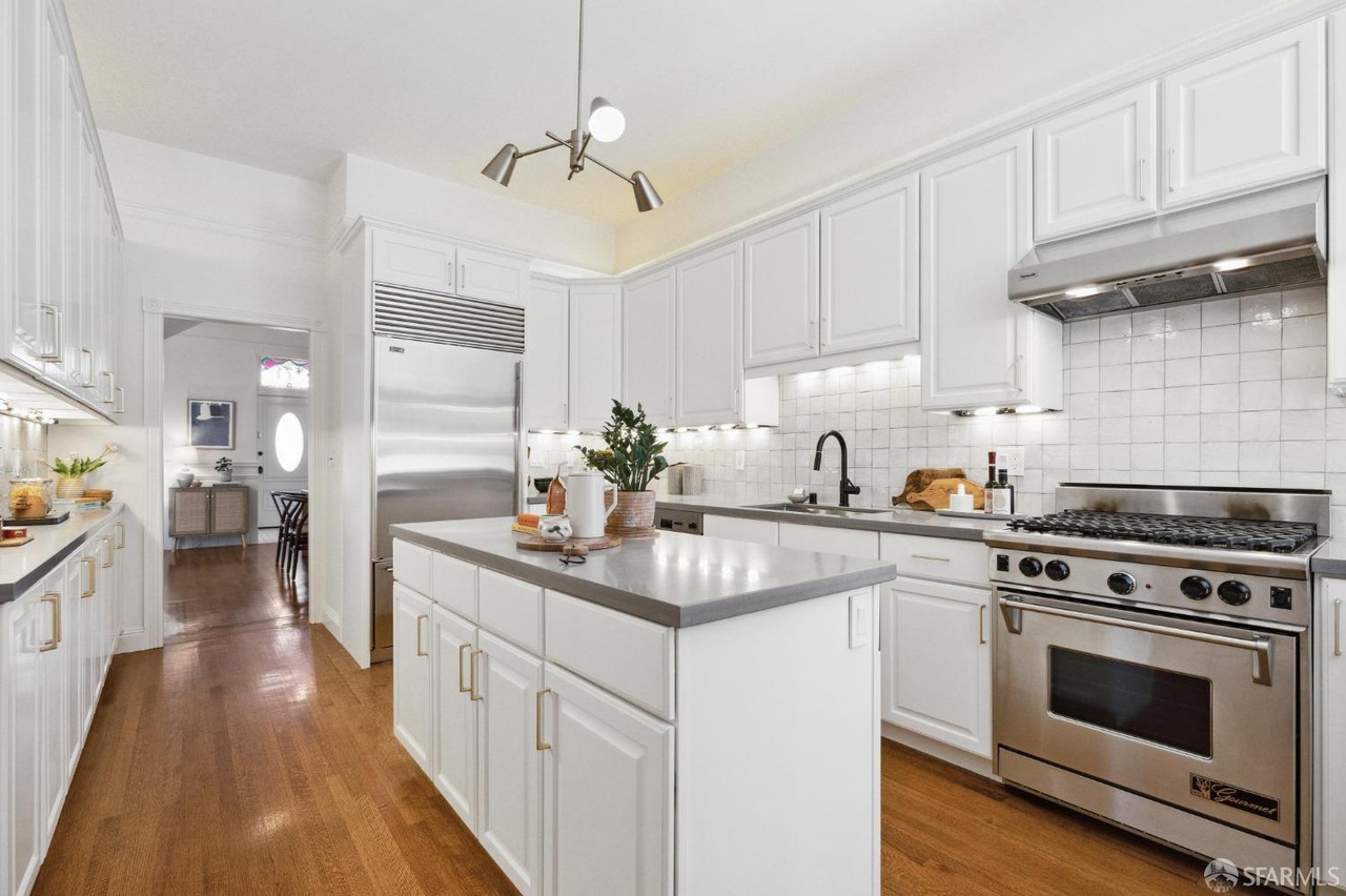 Property Photo: Kitchen has hardwood floors throughout and stainless steel appliances. 