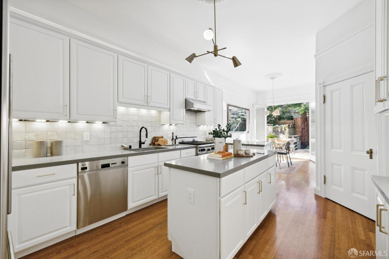Property Photo: Kitchen has white tile backsplash and small island.