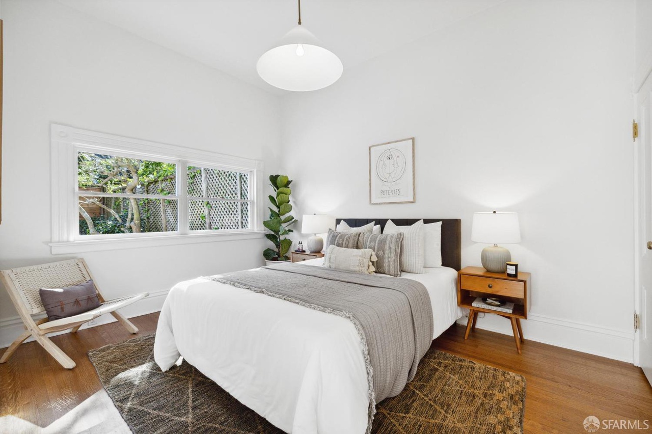 Property Photo: Bedroom has hardwood through out. There is a queen bed with two bedside tables.