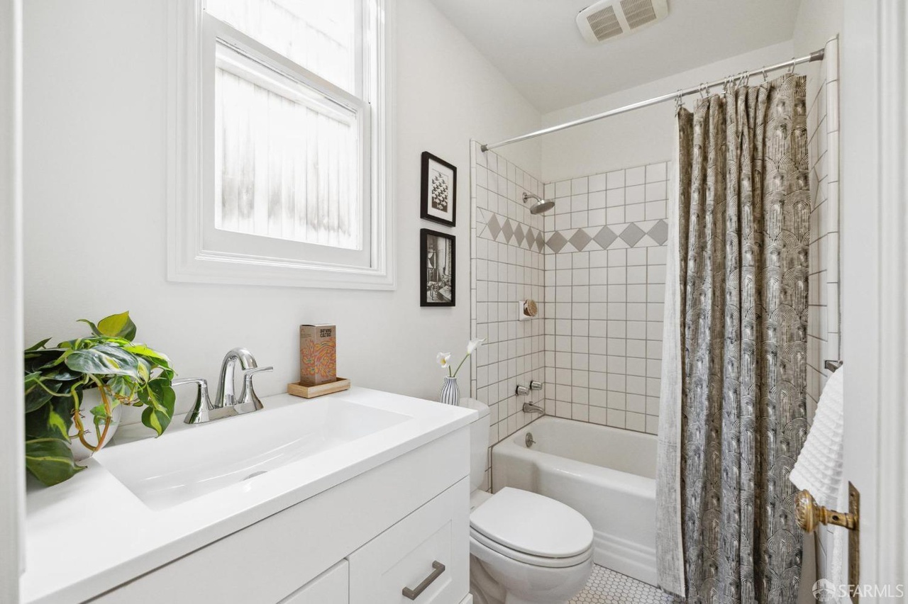 Property Photo: Bathroom has shower/tub combo with tile walls and floor.