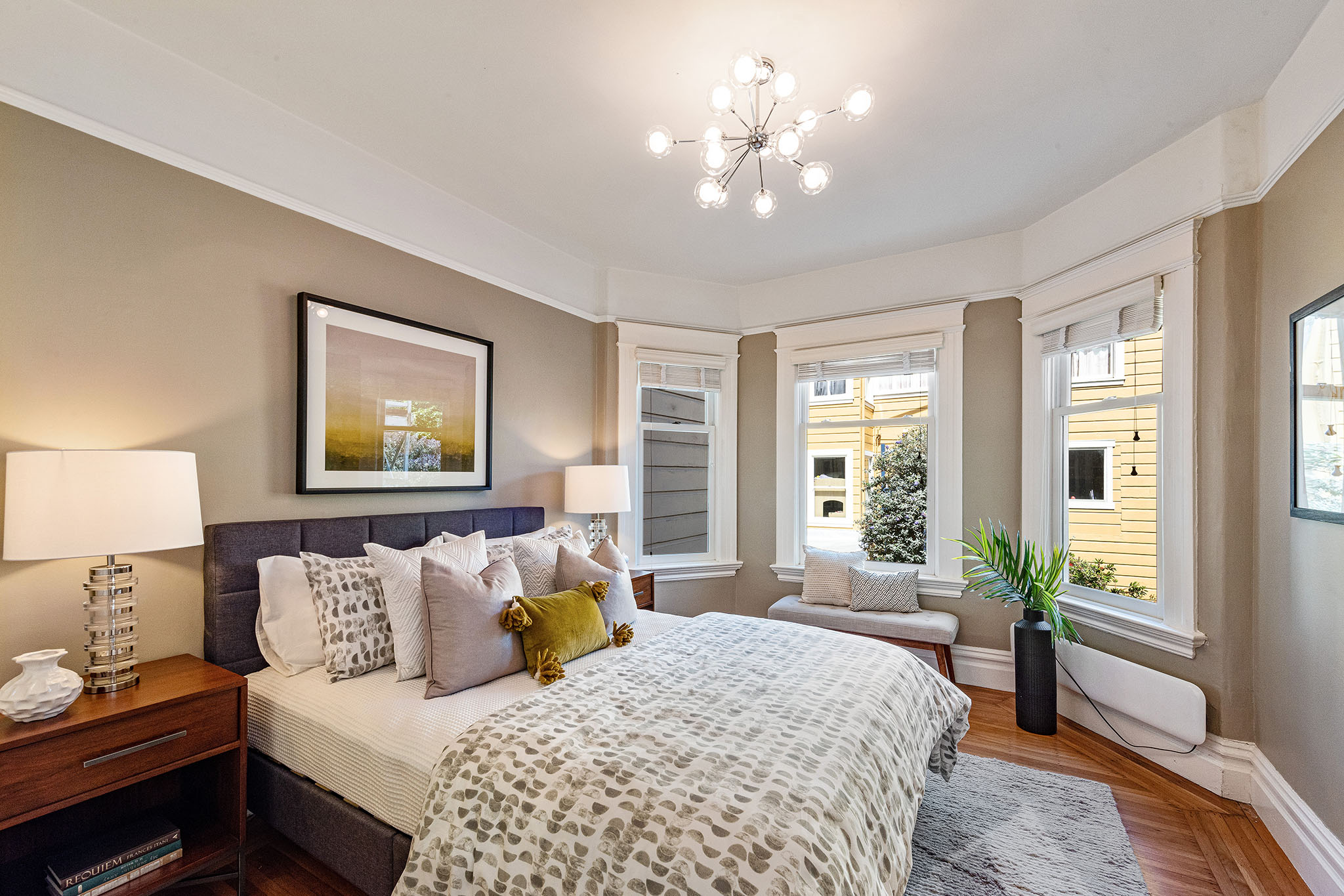 Property Photo: View of a large bedroom, showing three windows and wood floors