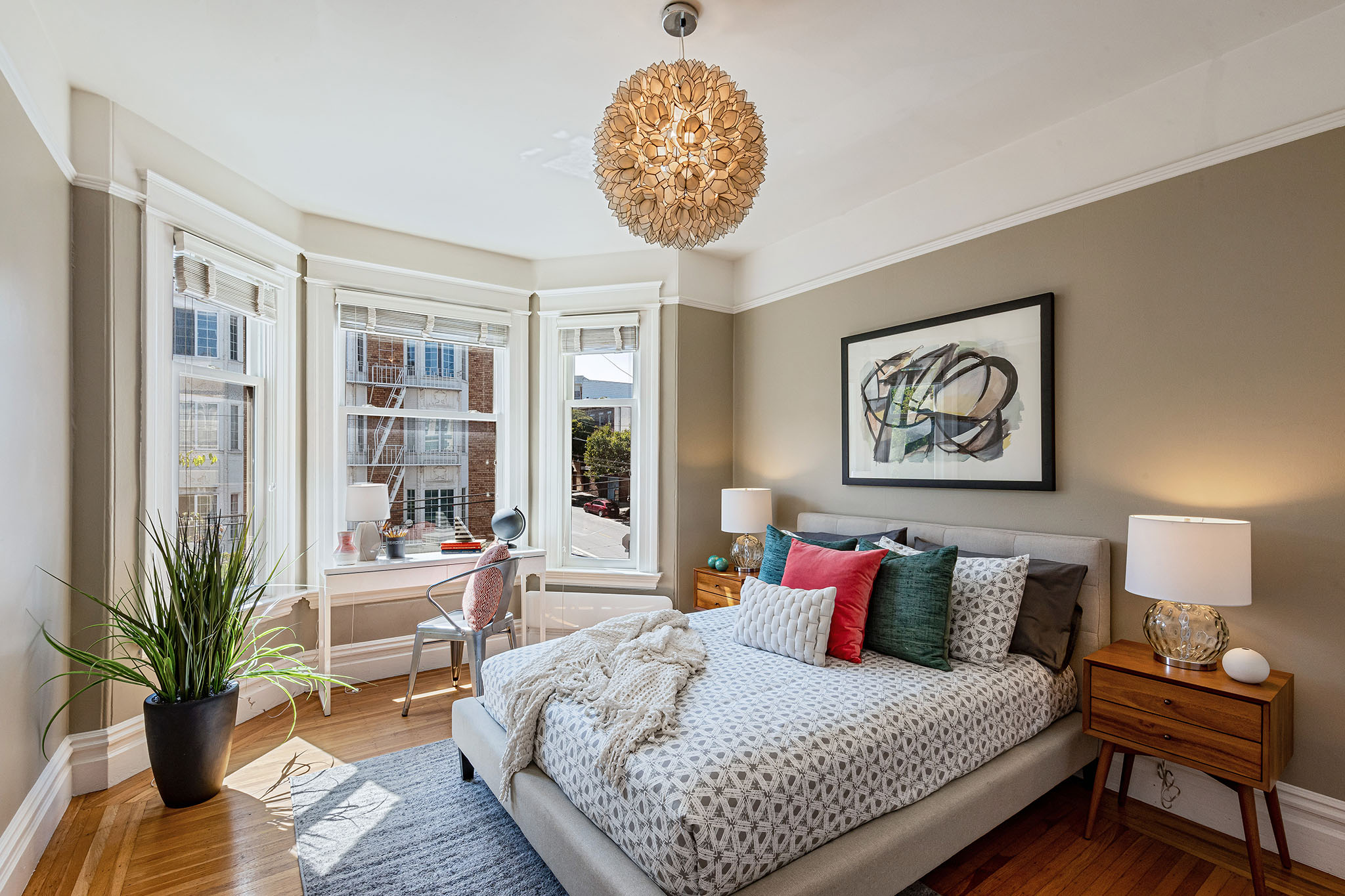 Property Photo: View of a second bedroom, showing large windows, modern light fixture , and wood floors