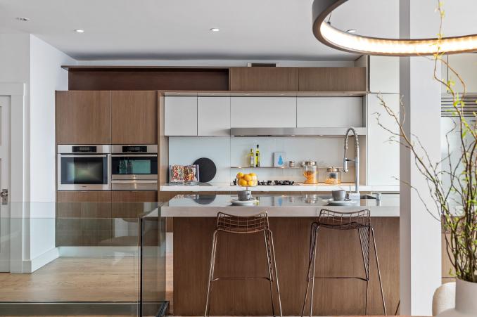 Property Thumbnail: View of the kitchen, showing wood cabinets and modern island seating