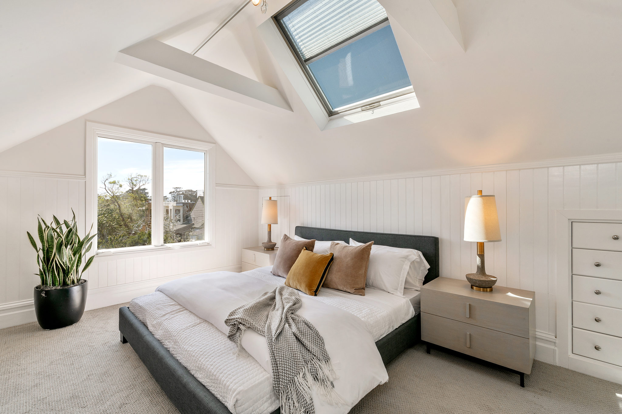 Property Photo: Bedroom with skylights and white wood walls