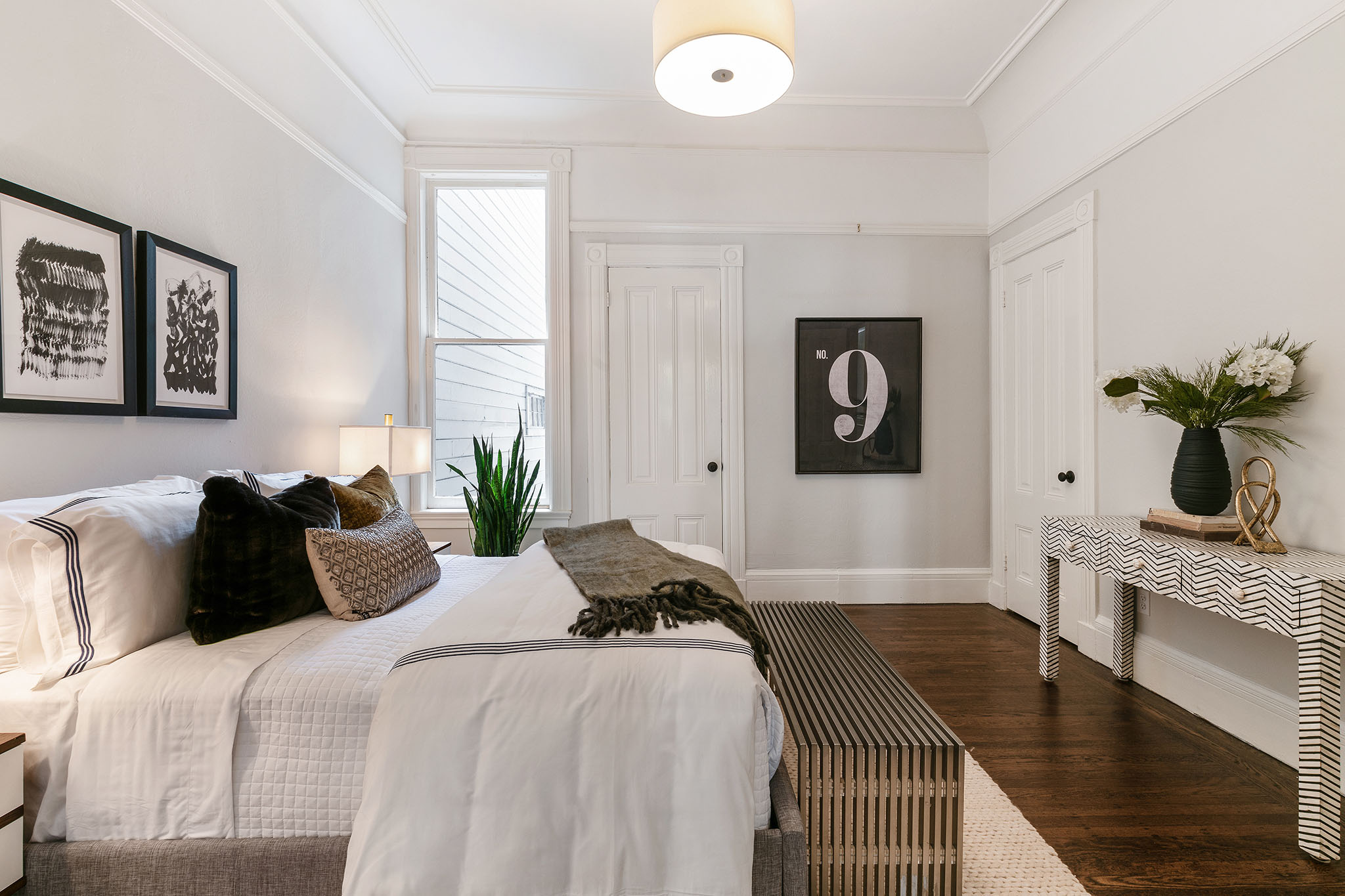 Property Photo: Bedroom with a window, crown moulding, and wood floors
