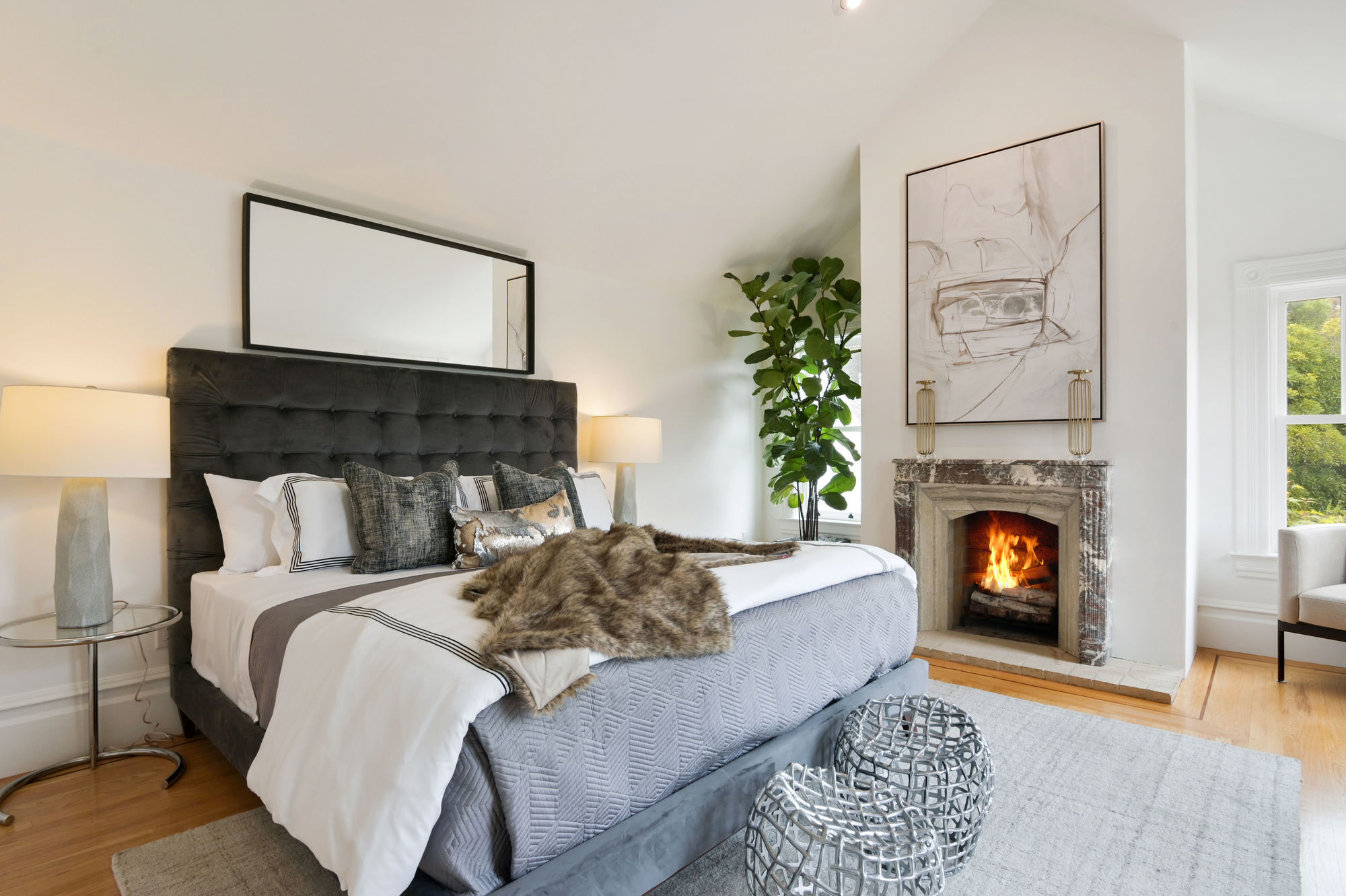 Property Photo: Primary bedroom with a fireplace and wood floors