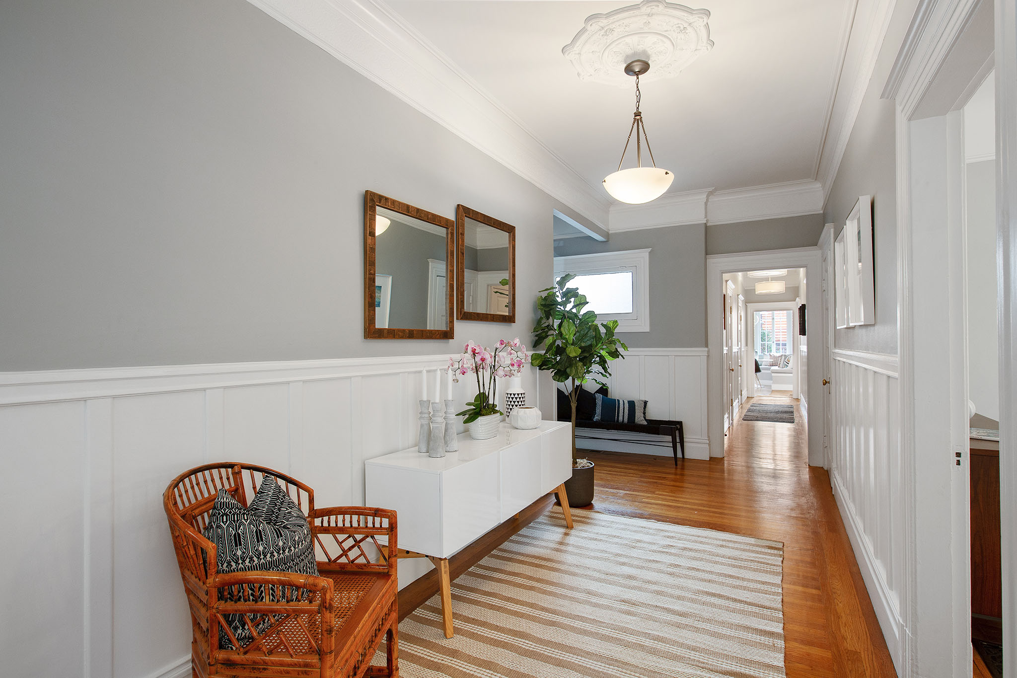 Property Photo: View of the hallway, showing wood floors and white wainscoting