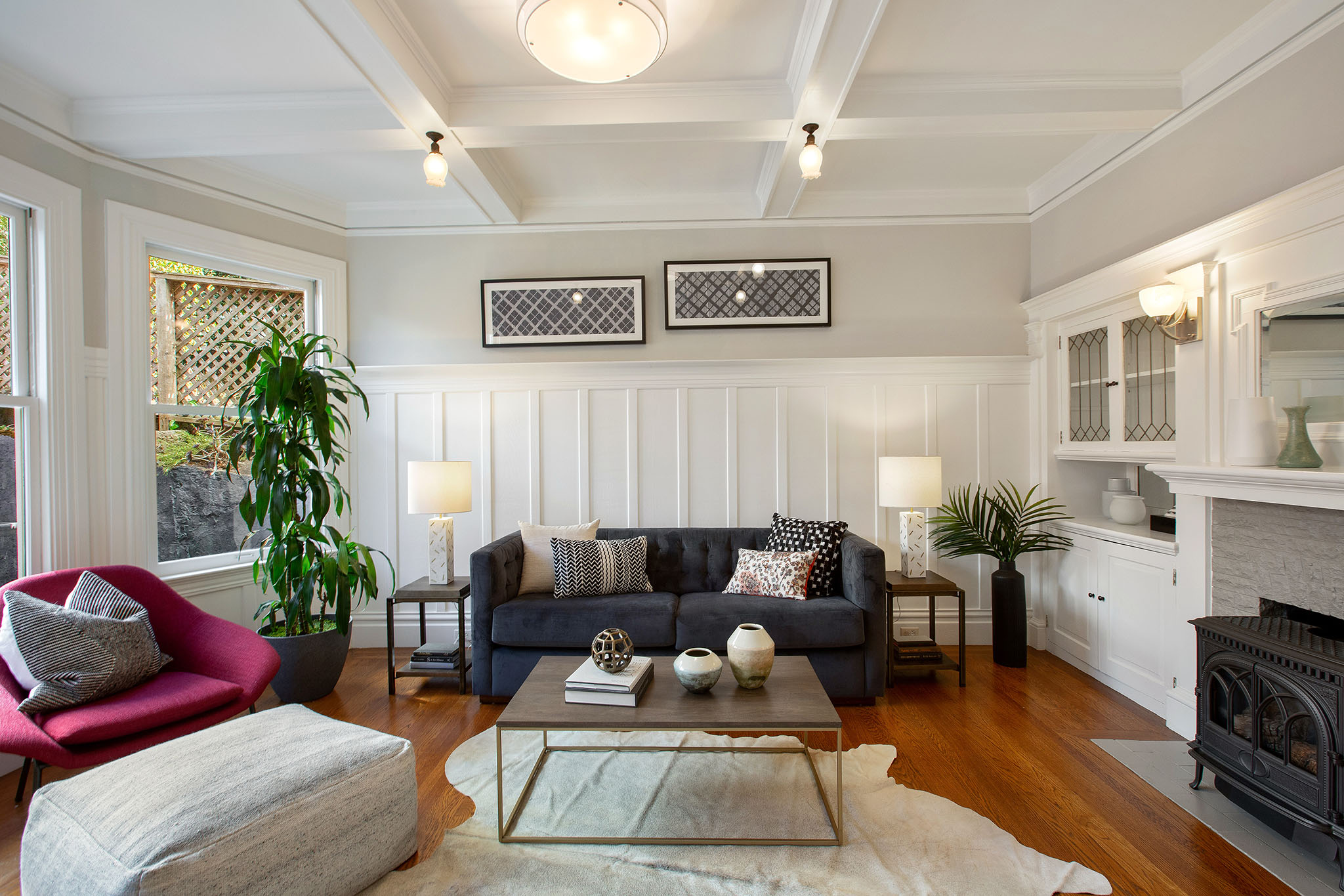 Property Photo: View of the living room, showing boxed ceilings, wood floors and white wainscoting