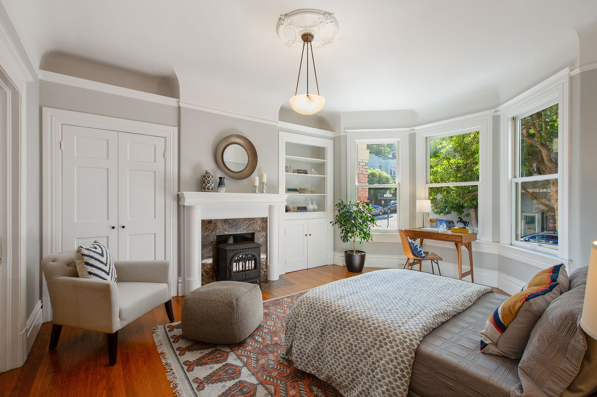 Property Photo: Bedroom with fireplace, wood floors and bay window