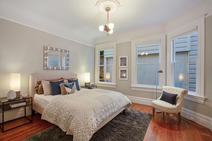 Property Thumbnail: View of a second bedroom, featuring wood floors and three large windows