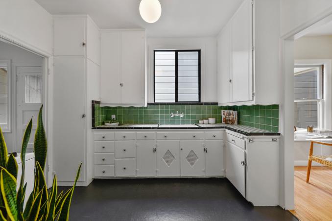 Property Thumbnail: Kitchen with green tile backsplash and white cabinets 