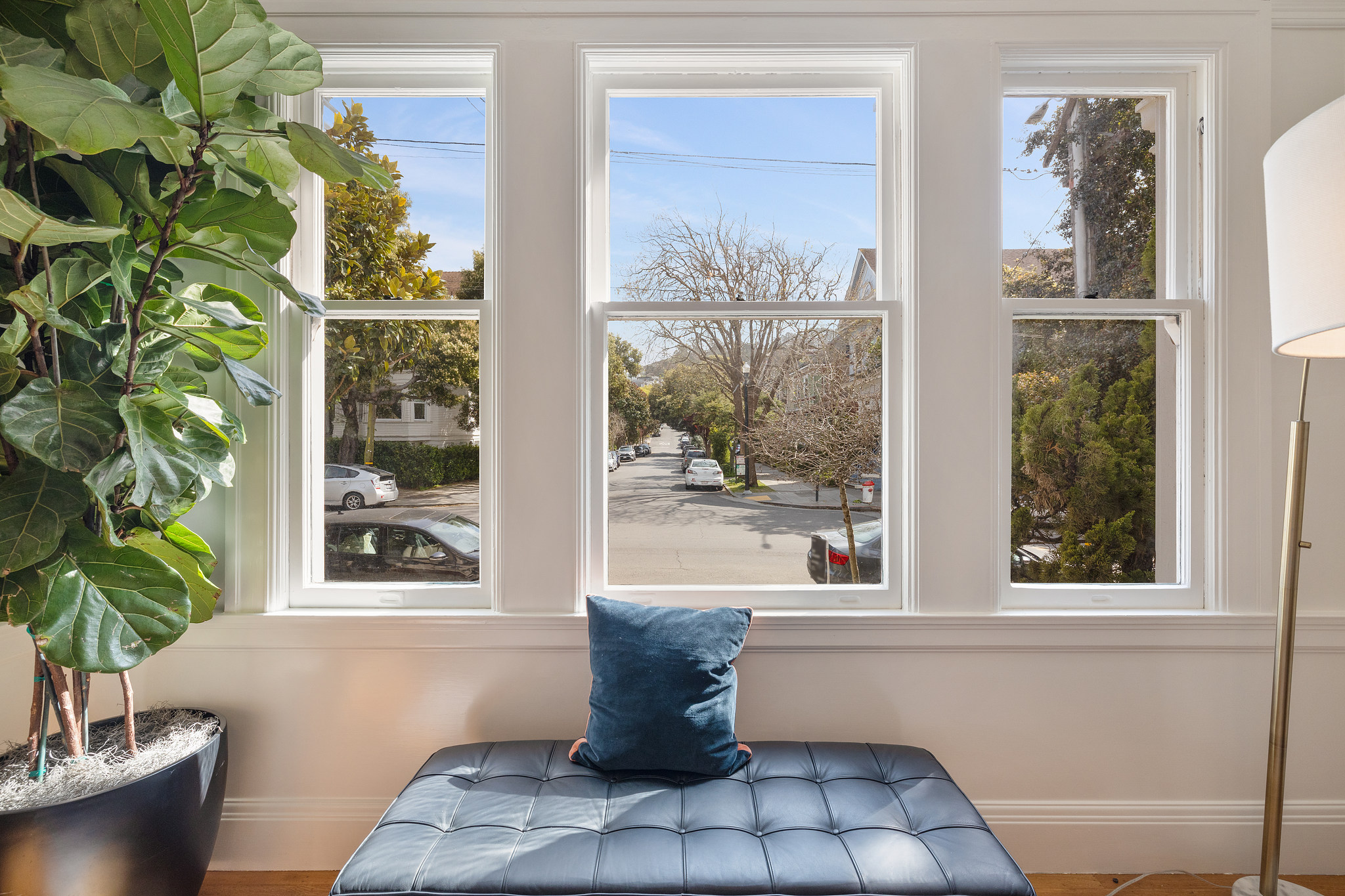 Property Photo: Close-up of the living room windows and view of the tree-lined street beyond