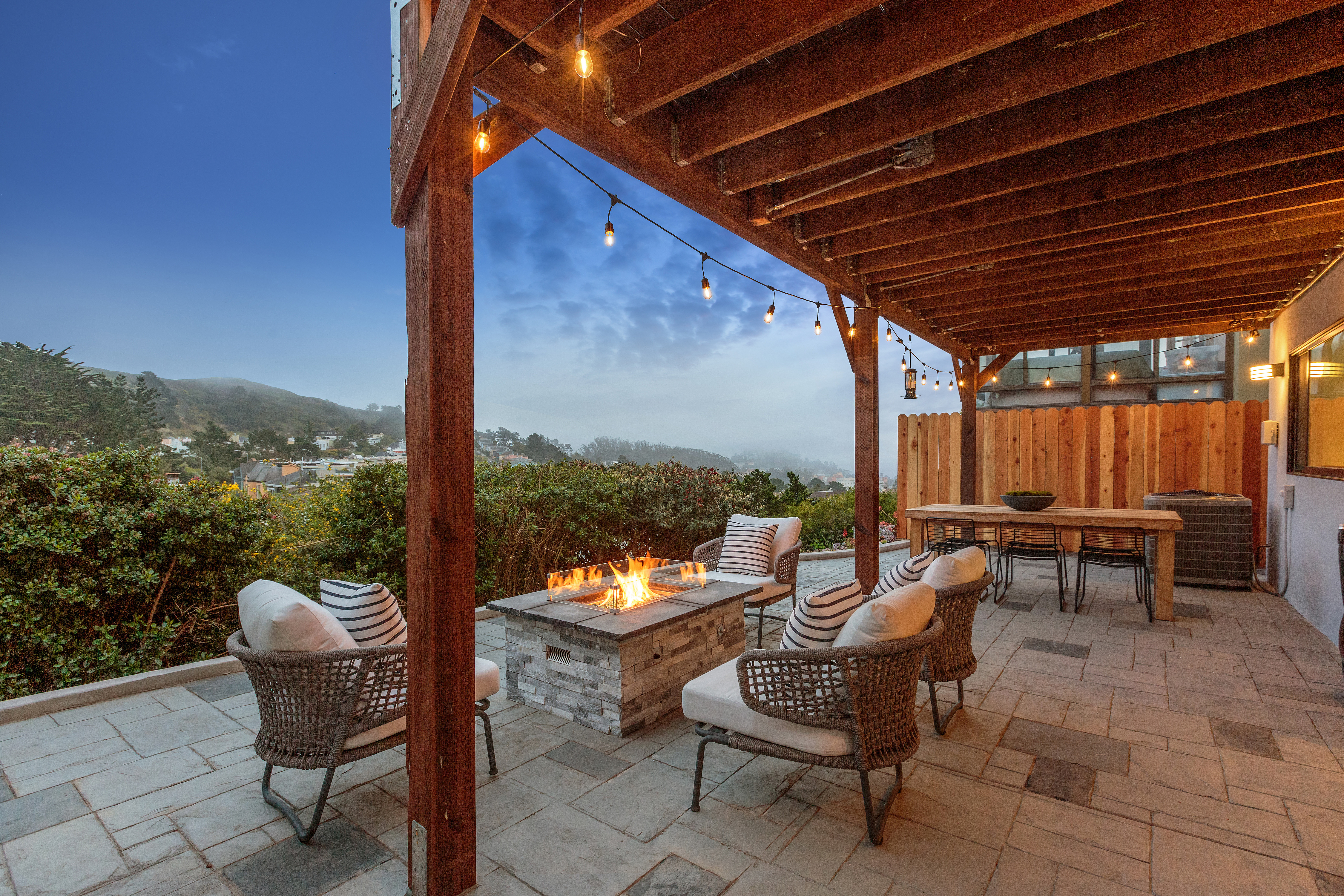 Property Photo: An outdoor fireplace and chairs with views of the city