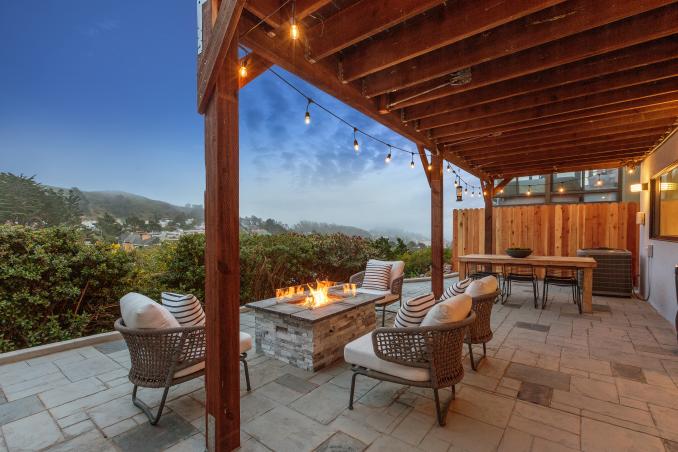 Property Thumbnail: An outdoor fireplace and chairs with views of the city
