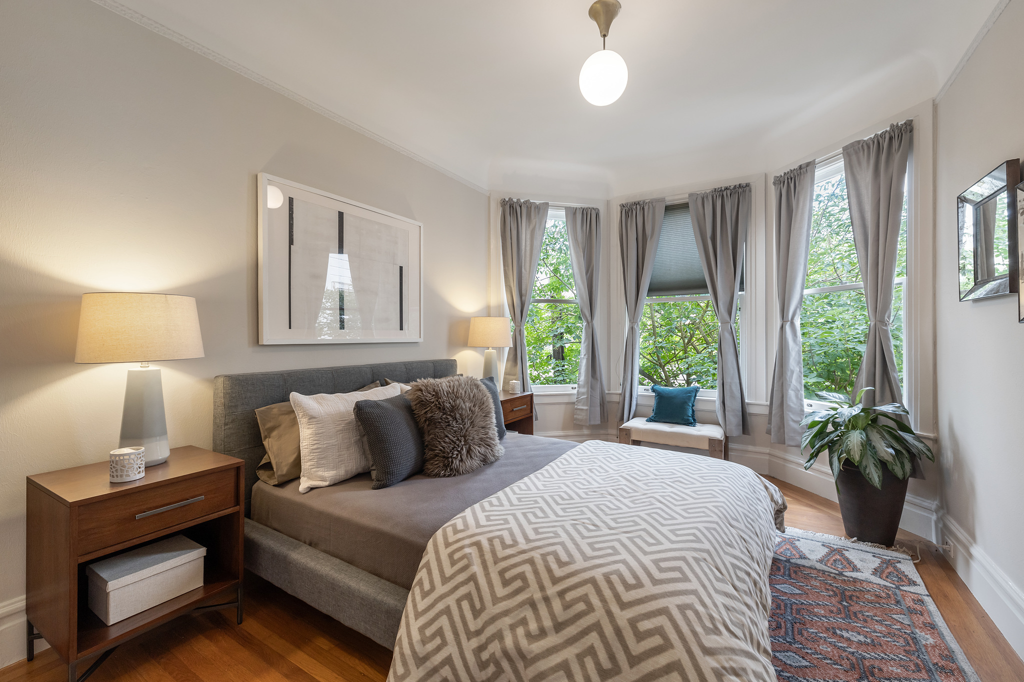 Property Photo: Large bedroom with bay windows and wood floors