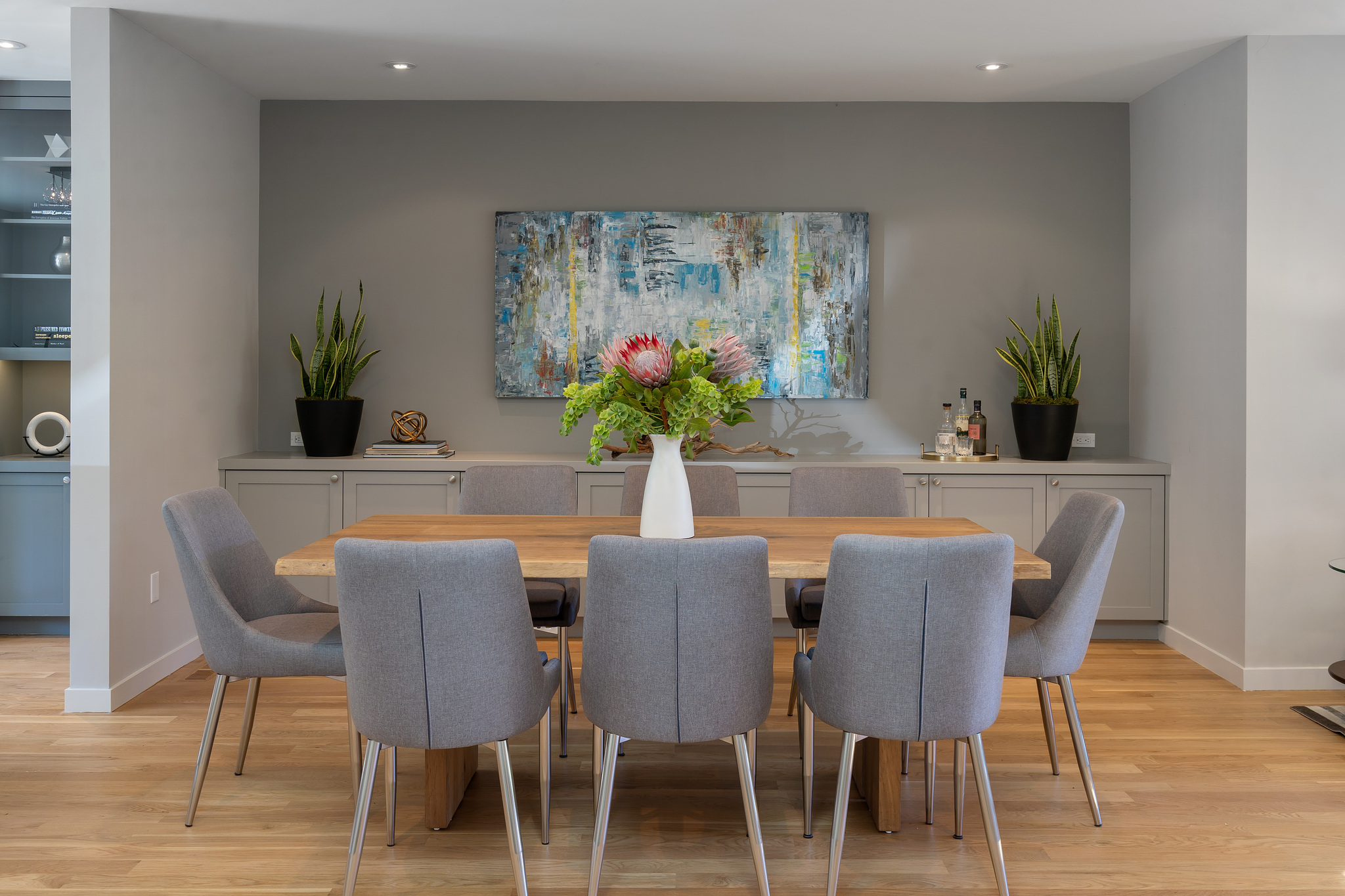 Property Photo: Dining area with wood floors and light grey cabinetry 