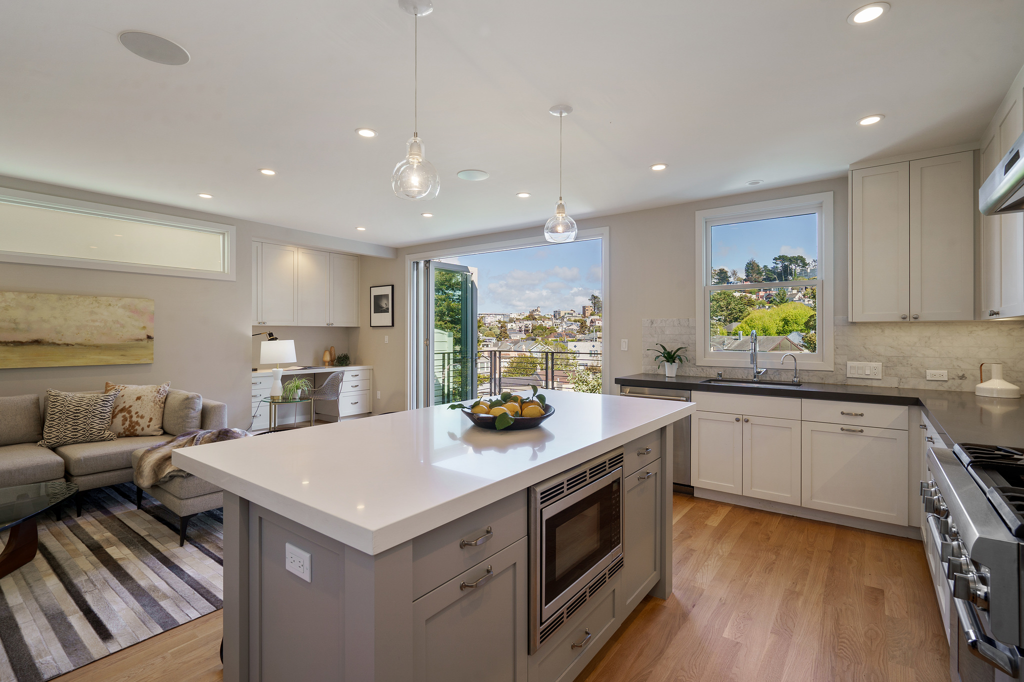 Property Photo: Kitchen island with oven and a view through open glass doors