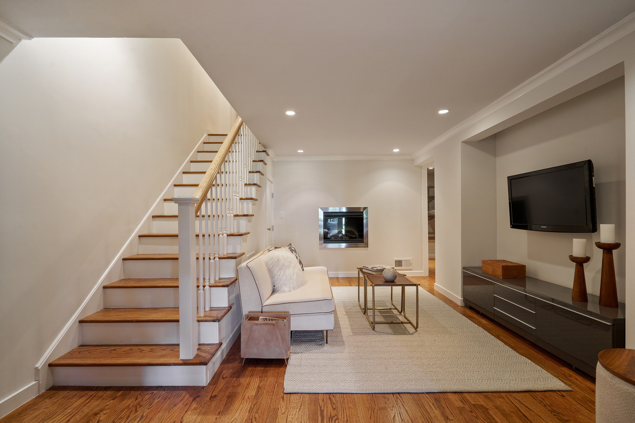 Property Photo: Lower level living area and wood stairs leading up