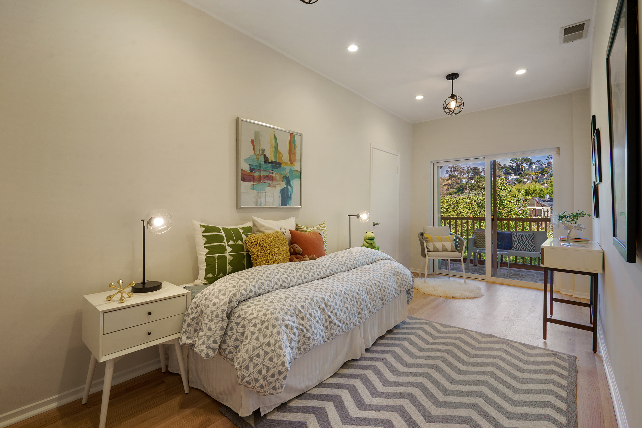 Property Photo: A smaller bedroom with a daybed, wood floors and glass patio doors