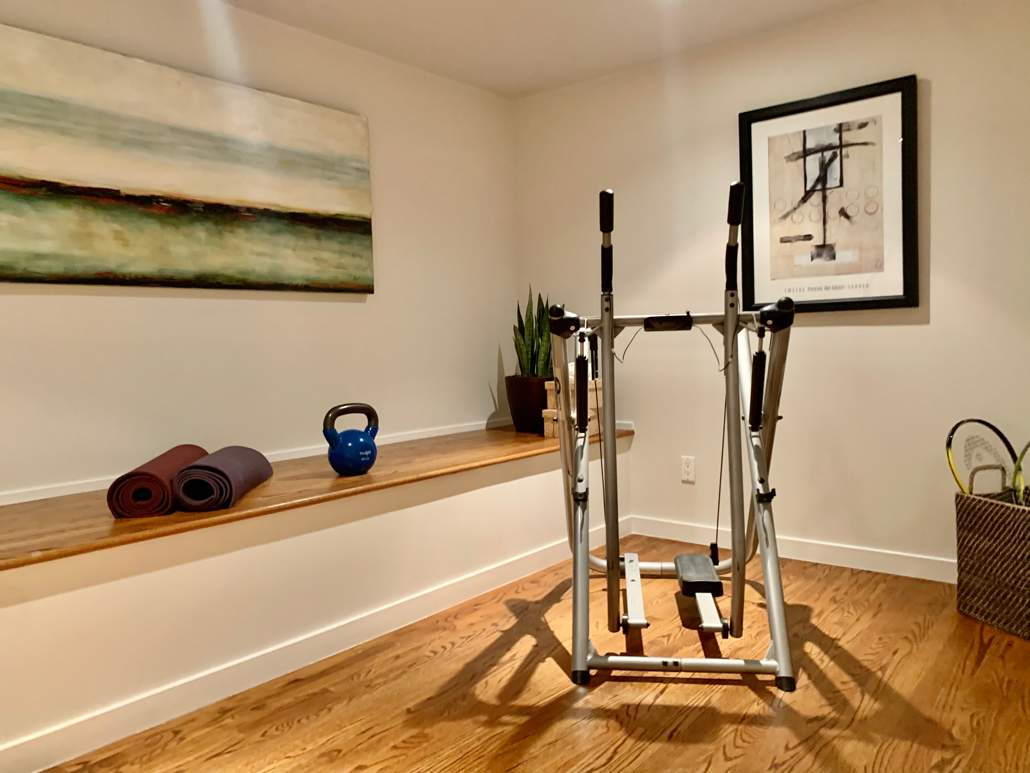 Property Photo: View of a home gym with wood floor and a built-in bench