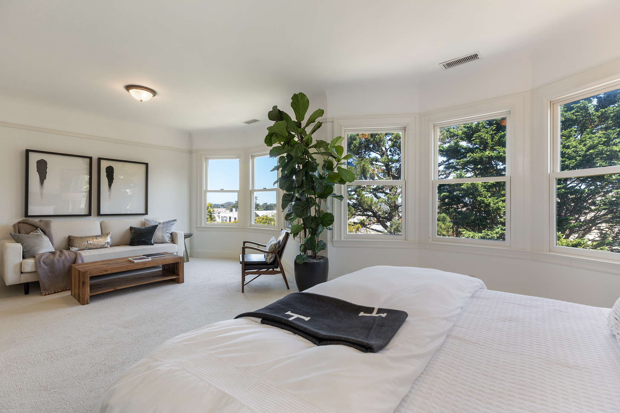 Property Photo: Bedroom with bay windows and lounge area 