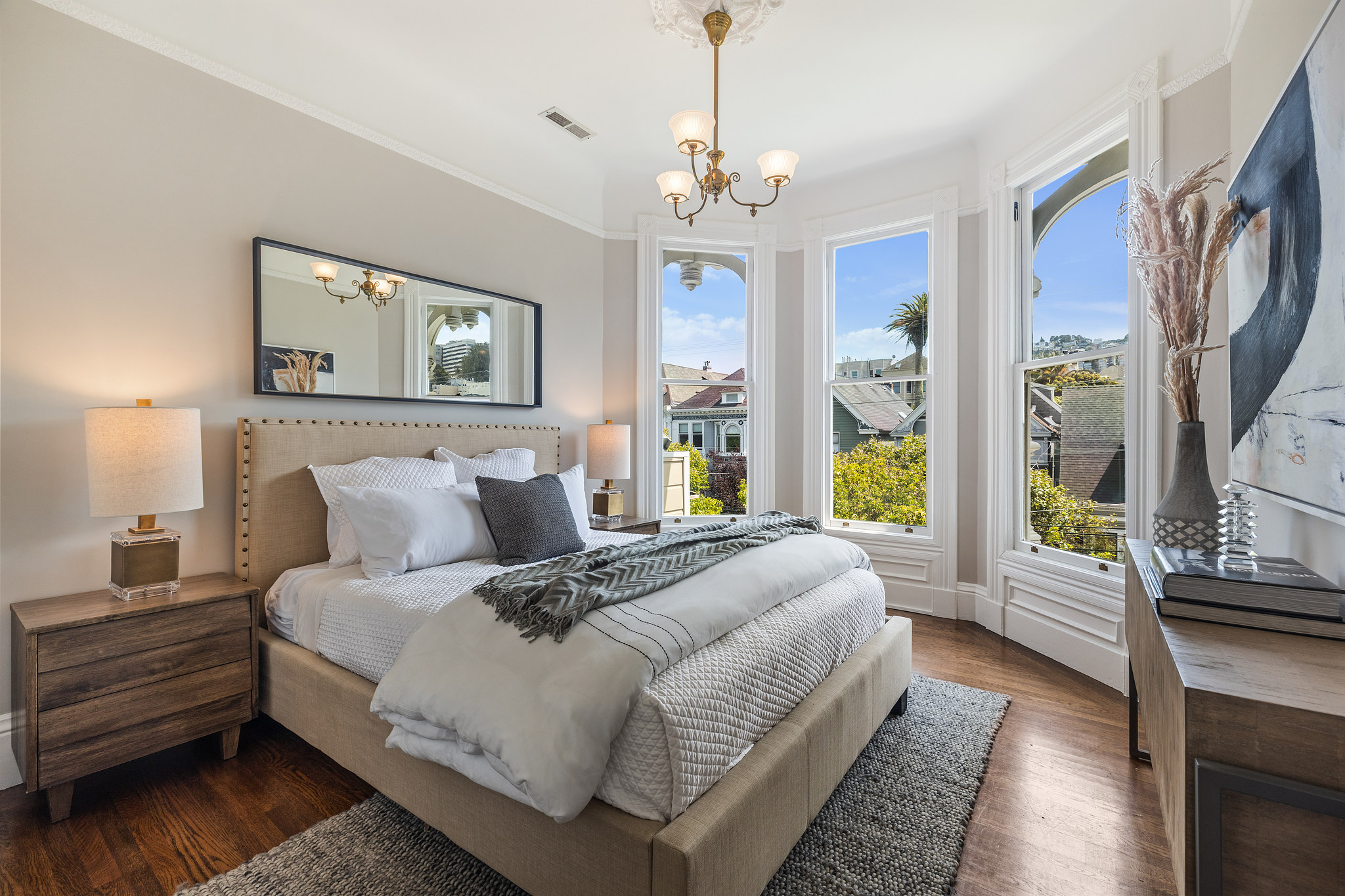Property Photo: View of a bedroom with bay windows and wood floors