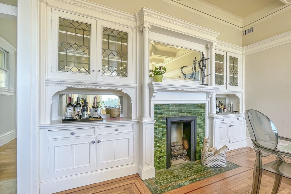 Property Photo: Formal dining room with fireplace, featuring green tile and white mantle