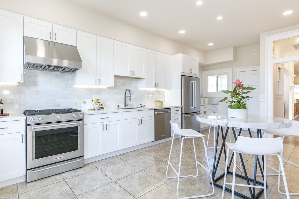 Property Photo: View of the kitchen, featuring tile floors and white cabinets