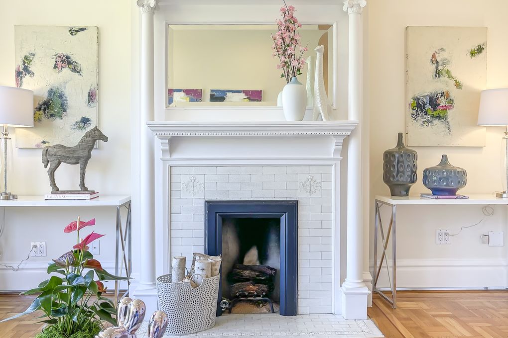 Property Photo: View of a white fireplace with intricately carved wood mantle