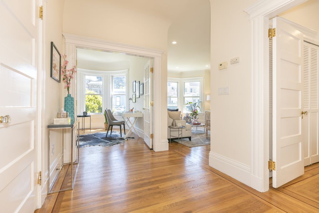 Property Photo: View of the hallway, featuring wood floors