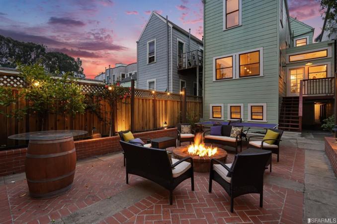 Property Thumbnail: View of the patio at twilight, featuring a fire in the outdoor fireplace 