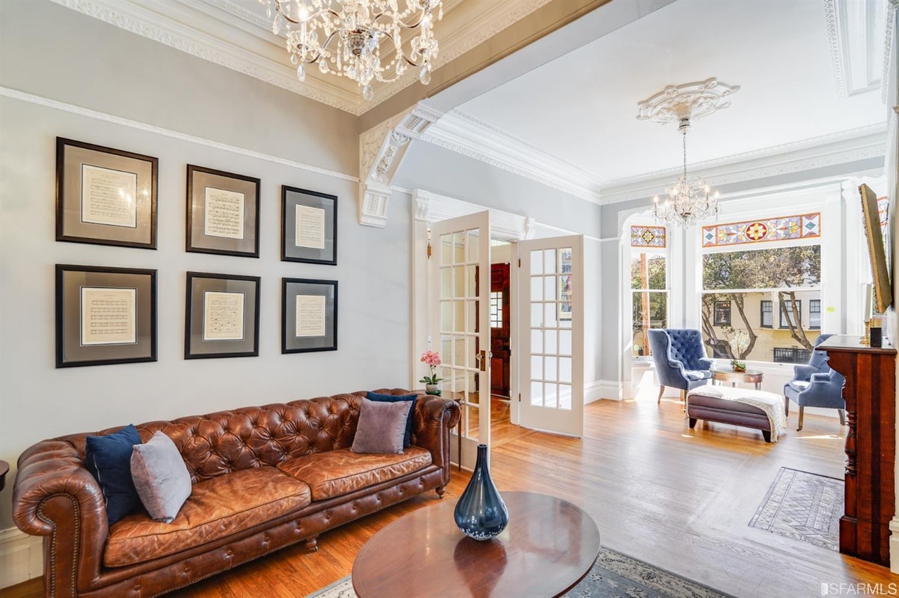Property Photo: View of the living room with chandeliers and crown moulding 