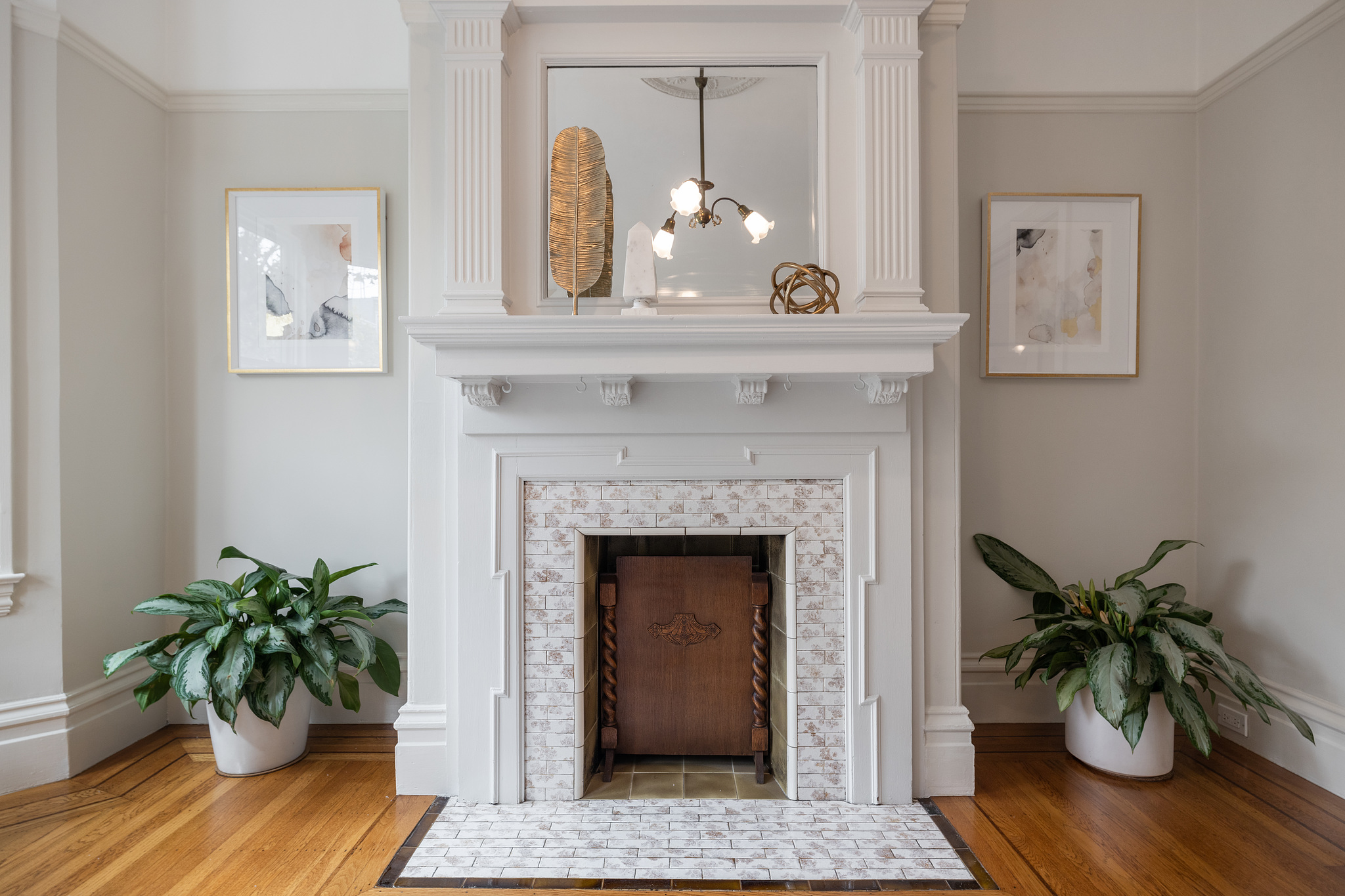Property Photo: Up-close view of a tiled fireplace with white wood