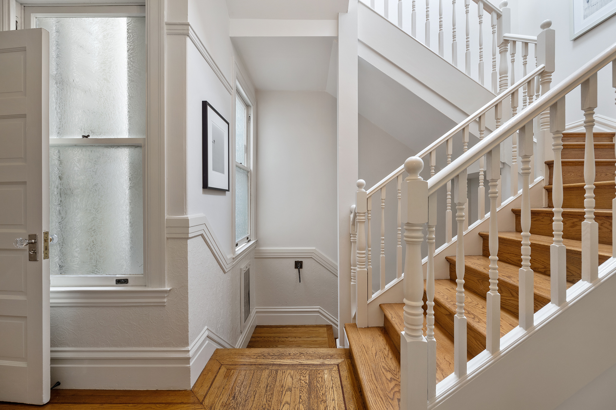 Property Photo: Wooden stairway with white railing 