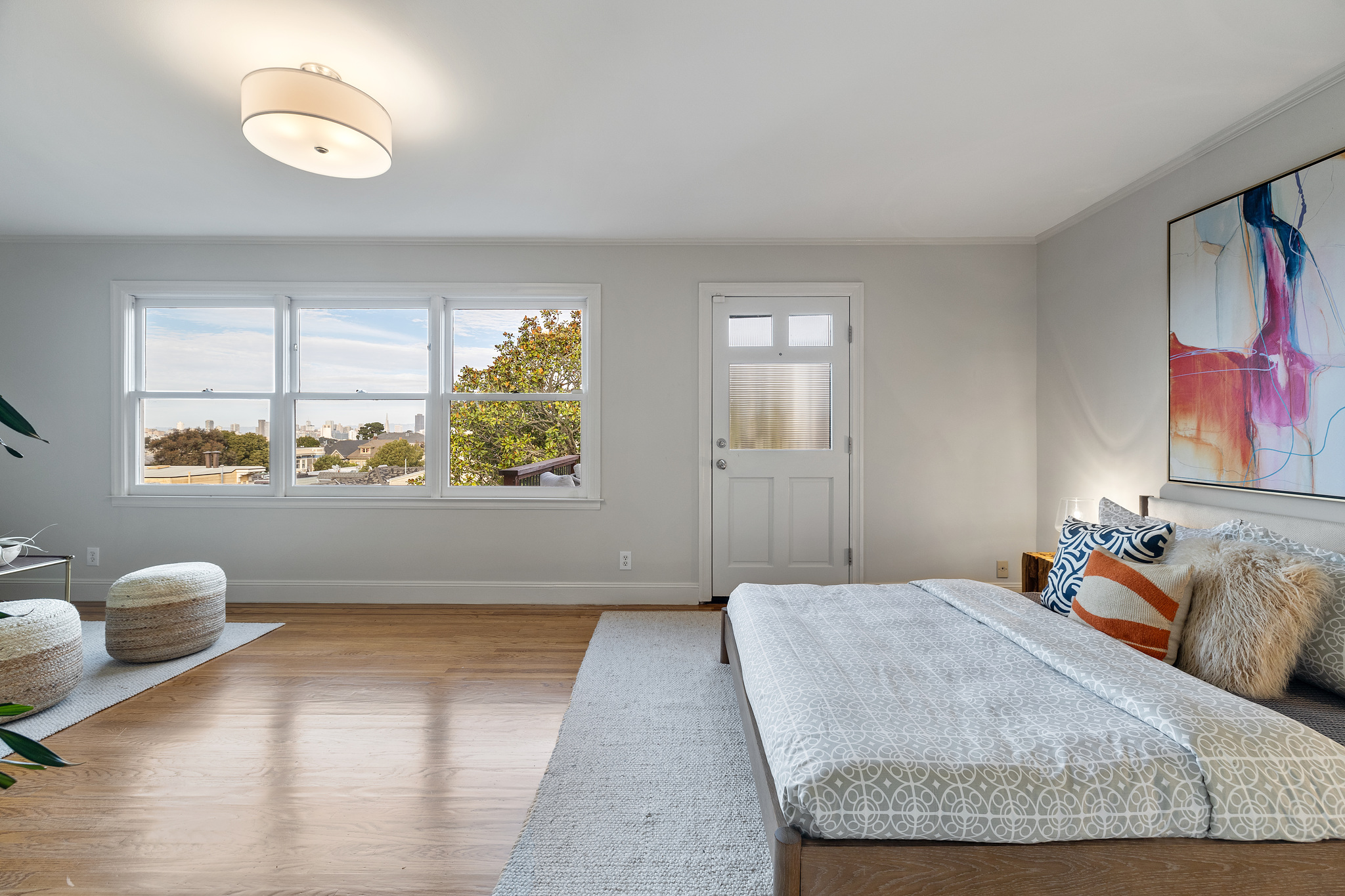 Property Photo: An expansive bedroom with three windows and a door leading to a private deck