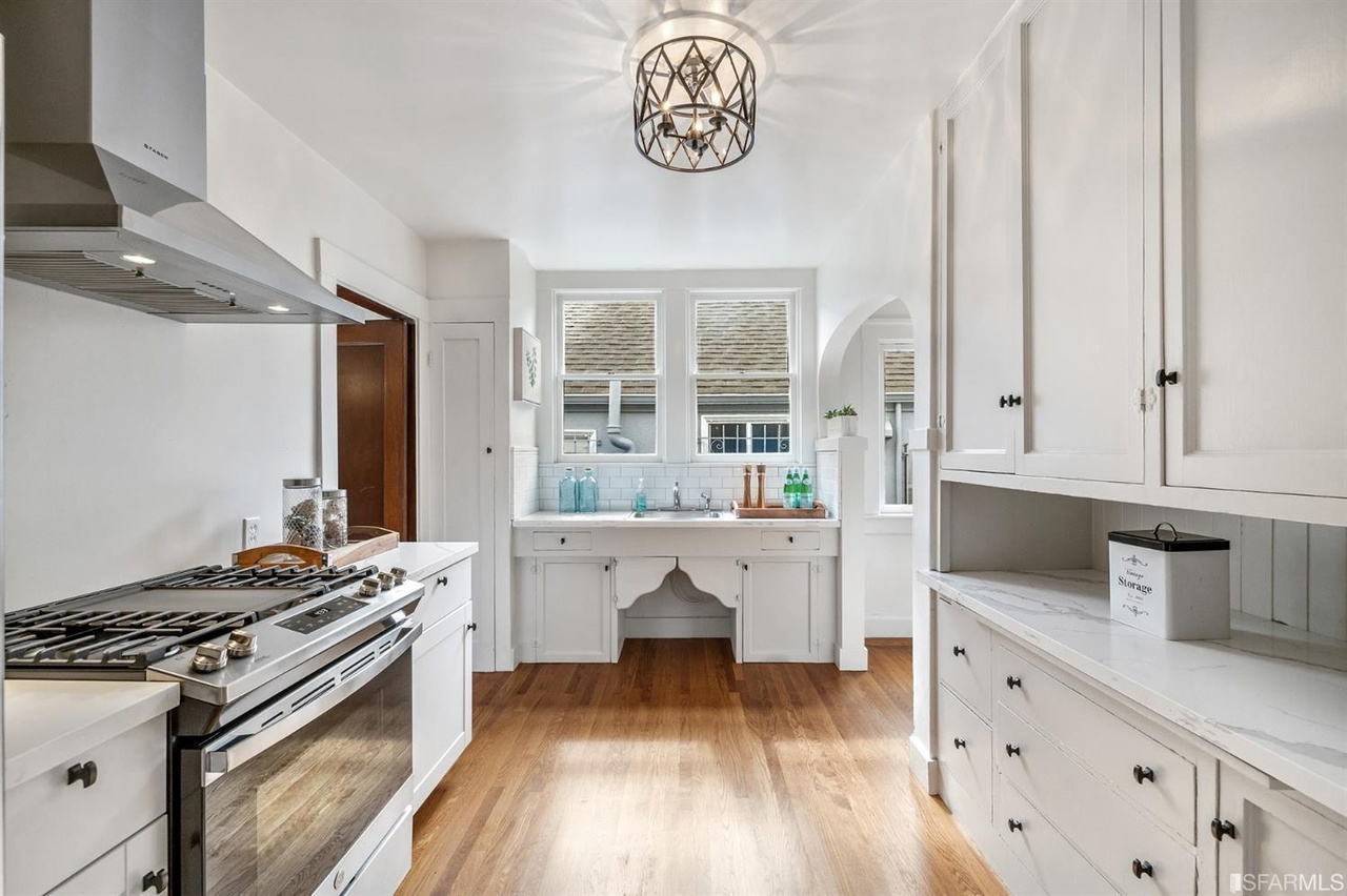 Property Photo: Galley style kitchen with white cabinets