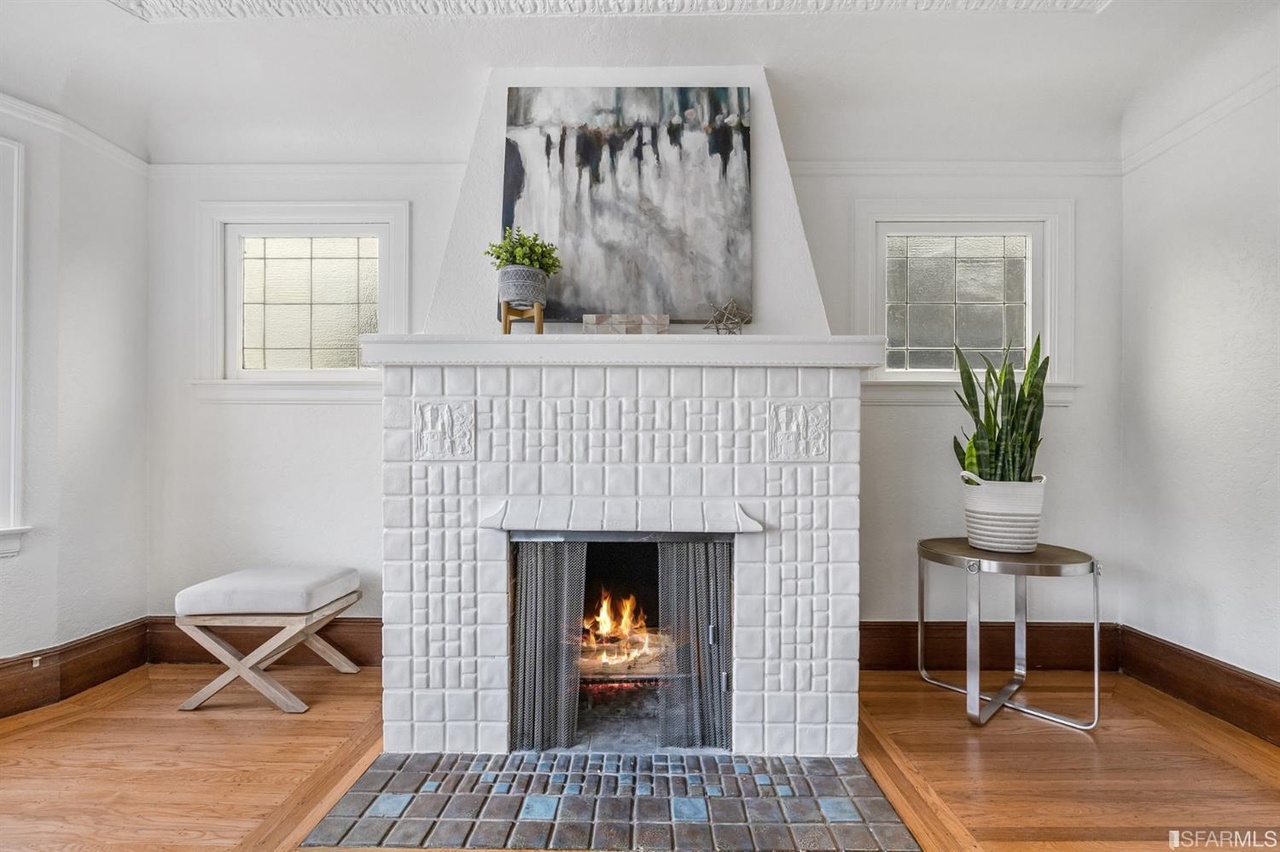 Property Photo: White fireplace with tiling is set between two windows 