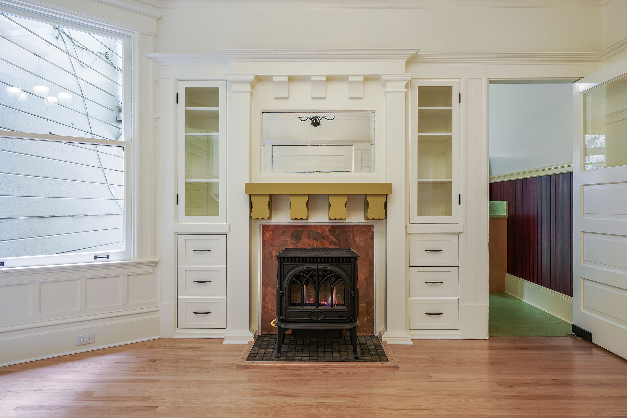 Property Photo: Close-up of the fireplace, and cabinets, showing a mirror above the mantle 