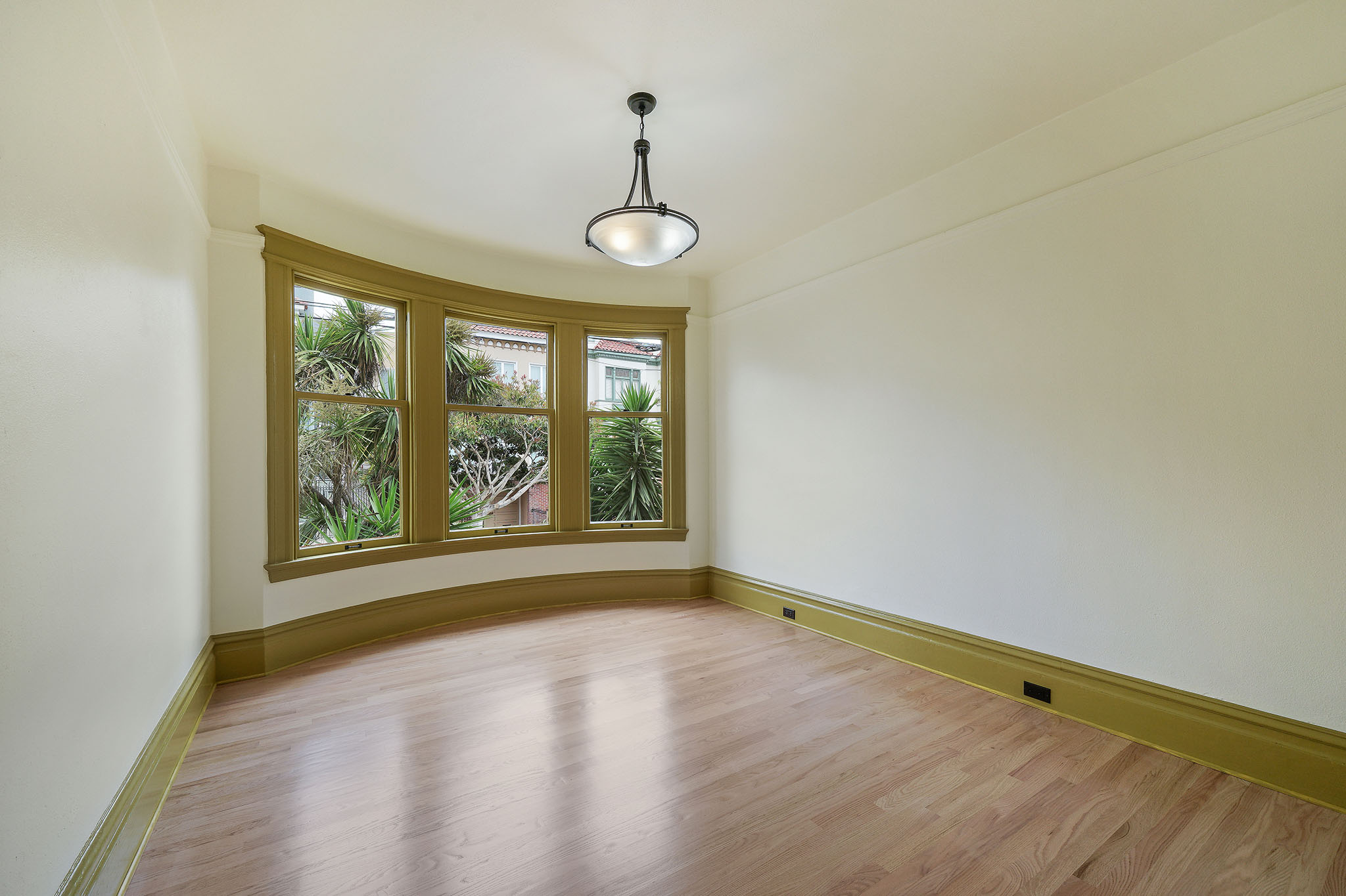 Property Photo: View of an unfurnished room, featuring wood floors and large windows