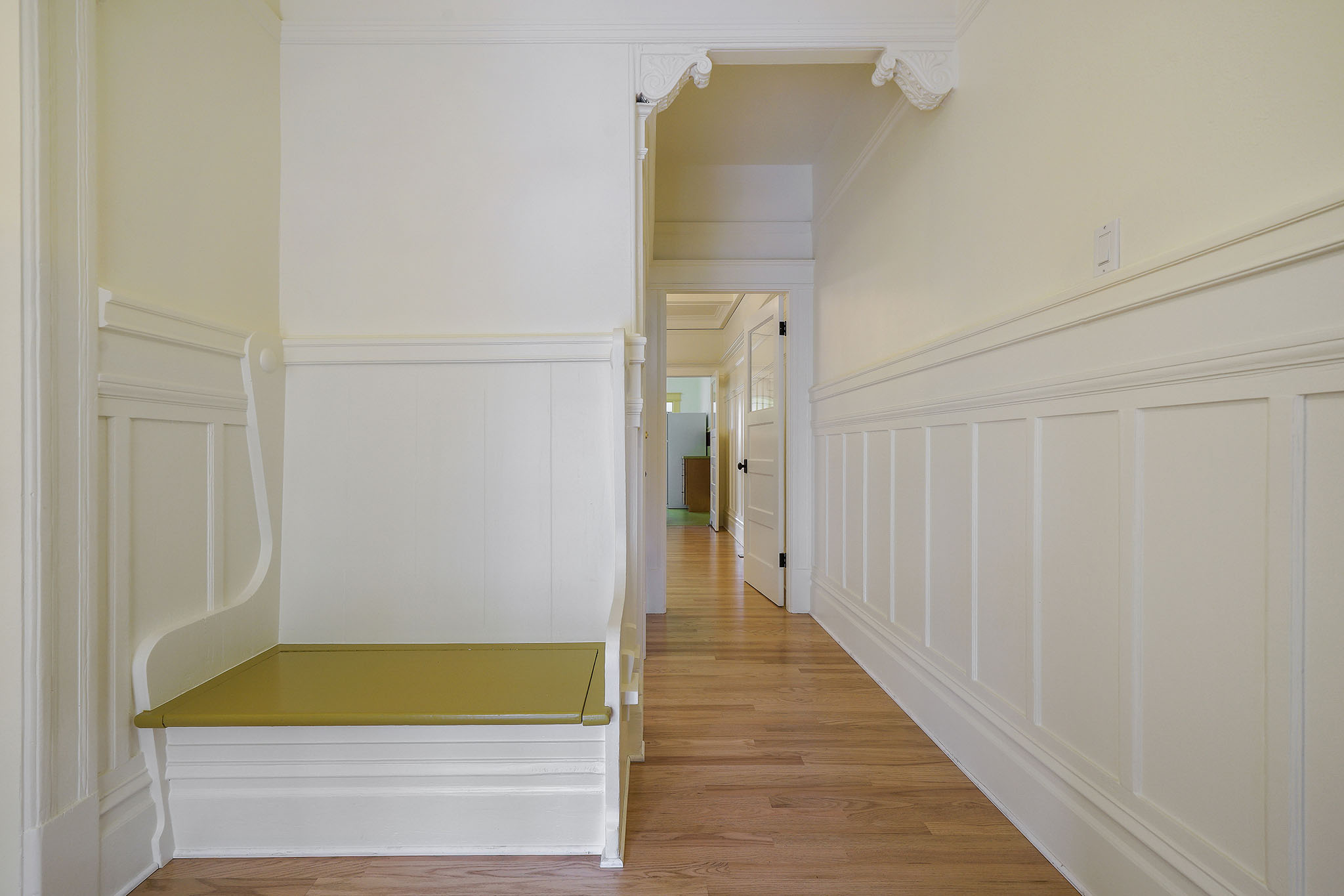Property Photo: Hallway with wood floors and beautiful wainscoting 