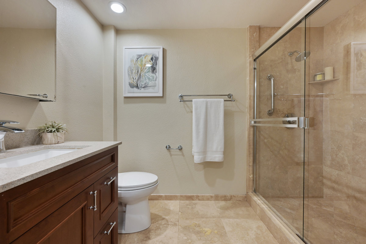 Property Photo: Lower unit bathroom, featuring a glass shower